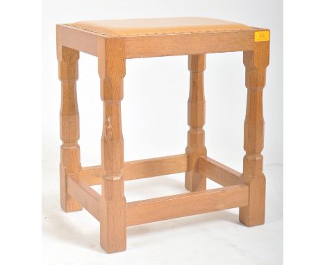 Robert ' Mouseman ' Thompson of Kilburn - A solid English oak hand carved leather top stool. The stool having a studded leath