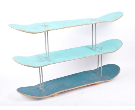 A contemporary bespoke handmade skateboard wall hanging shelving unit. The shelf made out of three painted skateboards united