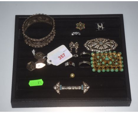 A group of costume jewellery including an early 20th century silver-backed paste brooch, paste "M" brooch, gilt-metal wirewor