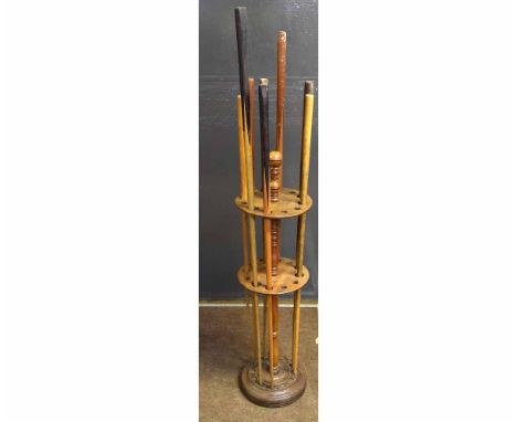 Victorian mahogany formed circular cue stand with a quantity of fitted cues, with turned finial to top, 29cms diam x 105cms h
