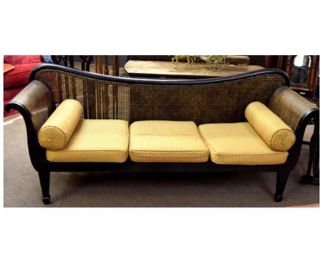 Good quality Bergere three-seater sofa with scroll arms and shaped back with gold upholstered cushions, raised on four taperi