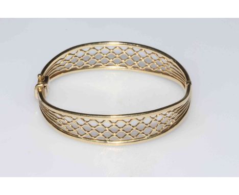 9 carat gold bangle with pierced decoration, (safety clasp damaged).