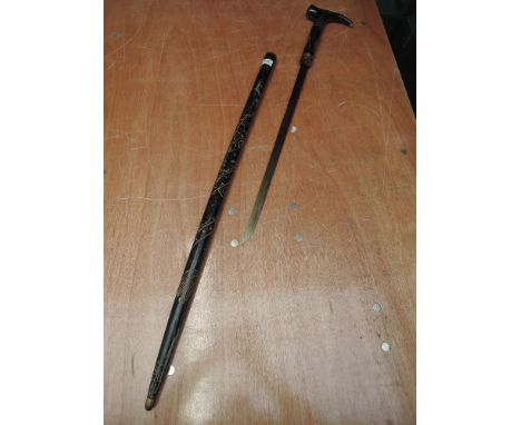 An early 20th century ebonized sword stick having coiled dragon decoration with carved face on handle, blade length 18.5 inch