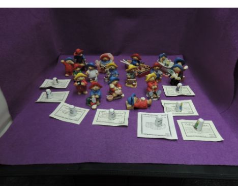 A collection of modern resin Paddington Bear figures along with a collection of ceramic thimbles