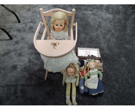 A Tri-ang wooden dolls folding High Chair, four celluloid and cloth dolls along with a miniature travel trunk with dolls hous
