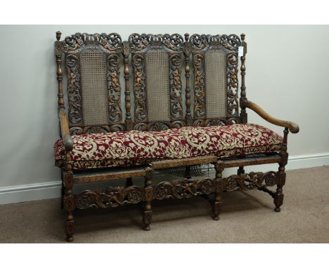 Early 20th century heavily carved Carolean style three seat settee settle, cane seat and back with upholstered loose cushion,