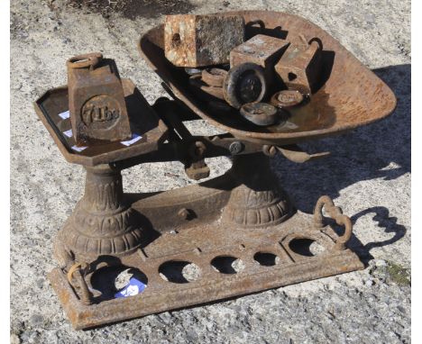 A vintage cast metal set of scales and a selection of related weights. 
