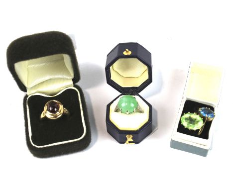 A vintage 9ct gold and garnet single stone ring and three gemset rings. The oval cabochon garnet rub-over set to a stepped he