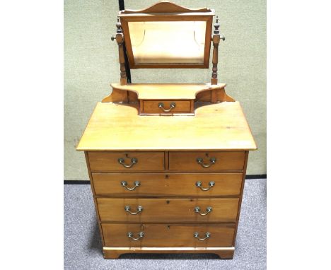 An early 20th century child's dressing table chest. The bevelled edge swing mirror raised upon a single short drawer, the che