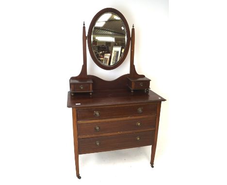 An Edwardian mahogany dressing table with mirror. The mirror suspended by a stand and flanked by two drawers, the base with t