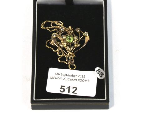 An Art Nouveau rose gold, peridot and half-pearl pendant/brooch. In the form of openwork scrolls with half-pearl trailing lea