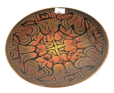 A large Poole pottery Aegean pattern charger. Decorated with a geometric pattern on a brown/orange ground, measuring 35cm dia
