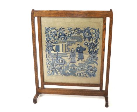 An early 20th century oak framed fire screen. Featuring a glazed panel displaying a needlepoint image similar to the willow p