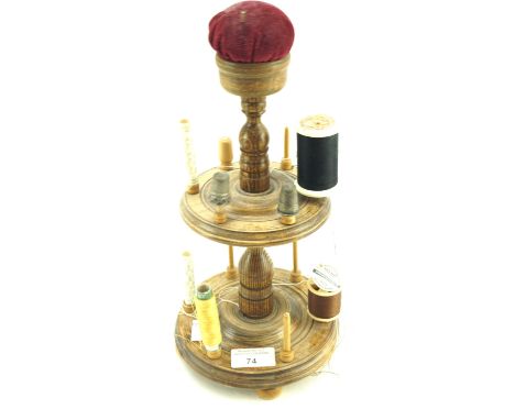A vintage treen bobbin holder. Two tiers with a pin cushion placed on the top, H30cm