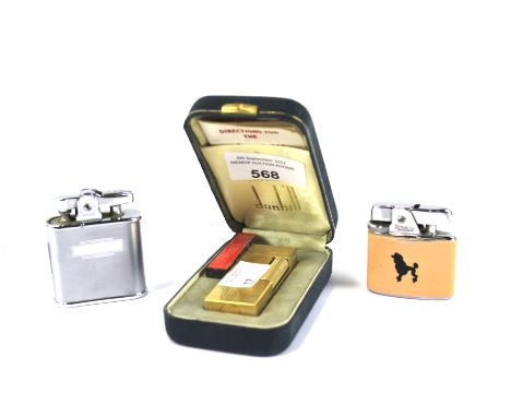 A Dunhill lighter and two Ronson lighters. The Dunhill lighter with a textured gilt case, in the original fitted box, one of 