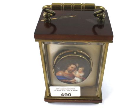 A yellow metal mounted painted porcelain brooch depicting a religious scene. Housed in a bevelled edged glazed front carriage