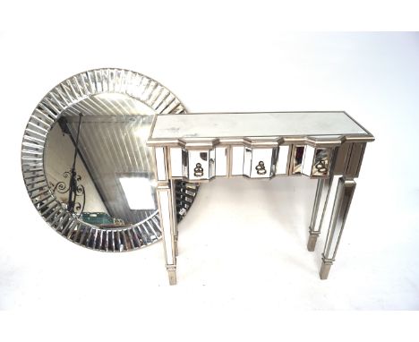 A contemporary chrome mirrored dressing table together with a similar wall mirror. The dressing table with three drawers to f