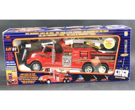 A boxed New Bright fire engine and remote control. With emergency lights and siren. Length of box 85cm