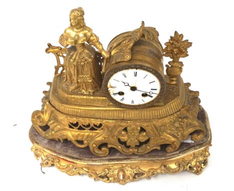 A gilt French style mantle clock. The enamel dial with Roman numerals, the case surmounted by a 17th century style lady and d
