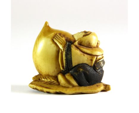 A 19th century Japanese carved and signed ivory netsuke of a figure holding a peach, L. 4.5cm, H. 3.5cm.