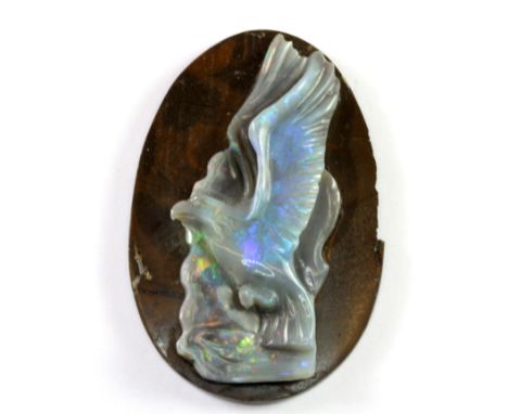 An unusual un-mounted carved blue opal decorated with an eagle. H. 5cms