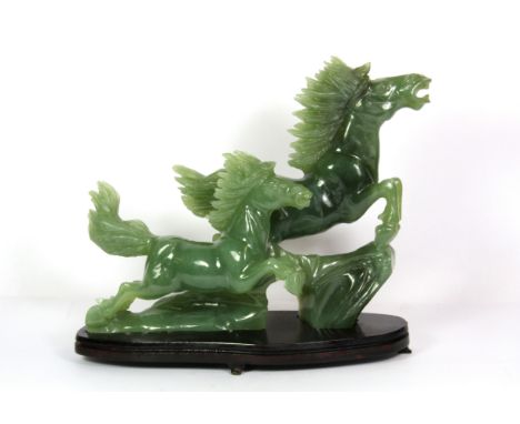 A mid 20th century Chinese carved jade / hardstone figure of a leaping horse on a wooden stand, H. 20cm.
