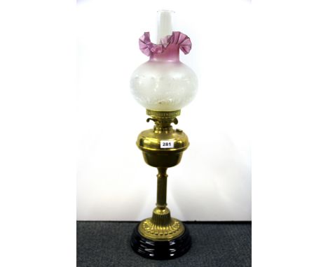 An Edwardian brass oil lamp on a black ceramic base, H. 71cm.