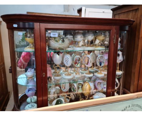 A glass display cabinet containing a number of collectable decorative eggs. Condition- some general wear to the wood to inclu