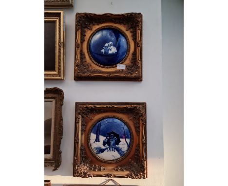 A pair of circular blue and white Delft ceramic plaques, diameter 17.5cm, gilt frames. 