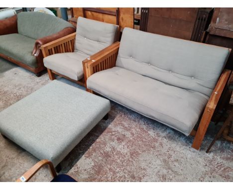 A wooden framed two seater sofa and matching armchair by the Futon company together with a large pouffe by Multiyork. 