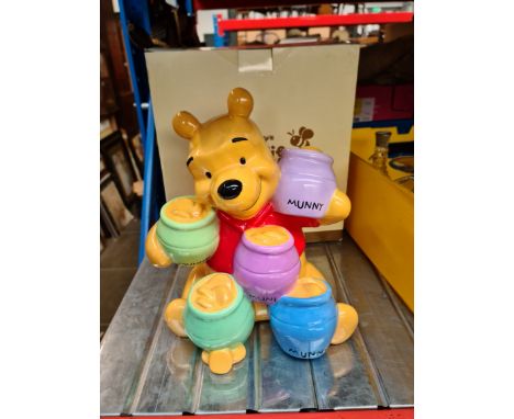 A Disney Winnie the Pooh ceramic piggy bank in box. 