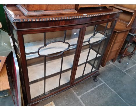 An early 20th century mahogany display cabinet on ball and claw feet. 