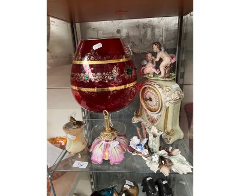 A large red glass, an onyx table lighter, a Capodimonte mantle clock and floral ornament, and a ceramic and brass ceiling lig