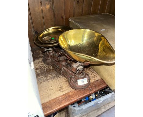 A vintage cast metal set of weighing scales with brass trays and few weights. 