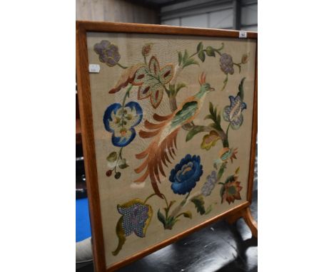 A traditional oak frame embroidered firescreen