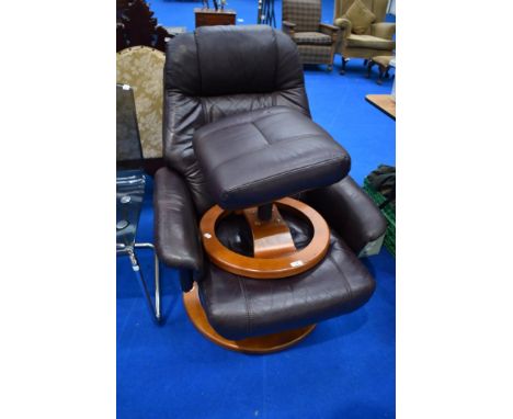 A vintage brown leather swivel chair and similar footstool, similar to stressless
