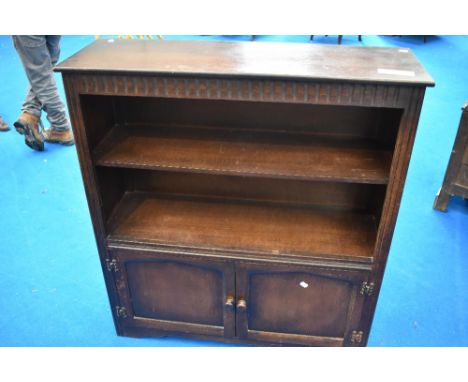 A vintage Priory or dark Ercol bookshelf with cupboard under