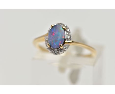 A 9CT GOLD OPAL DOUBLET RING, oval opal cabochon doublet, four claw set in yellow gold, within a single cut diamond halo lead