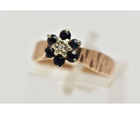 A 1970S 9CT GOLD SAPPHIRE AND DIAMOND CLUSTER RING, AF, the single cut diamond, within a surround of six circular cut sapphir