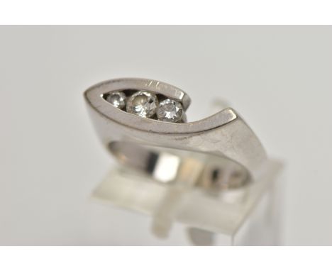 A WHITE METAL DIAMOND RING, the ring head of an abstract lozenge shape, set with three graduated round brilliant cut diamonds