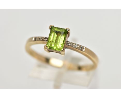 A 9CT GOLD PERIDOT AND DIAMOND DRESS RING, the rectangular shape peridot, within a claw setting, to the brilliant cut diamond