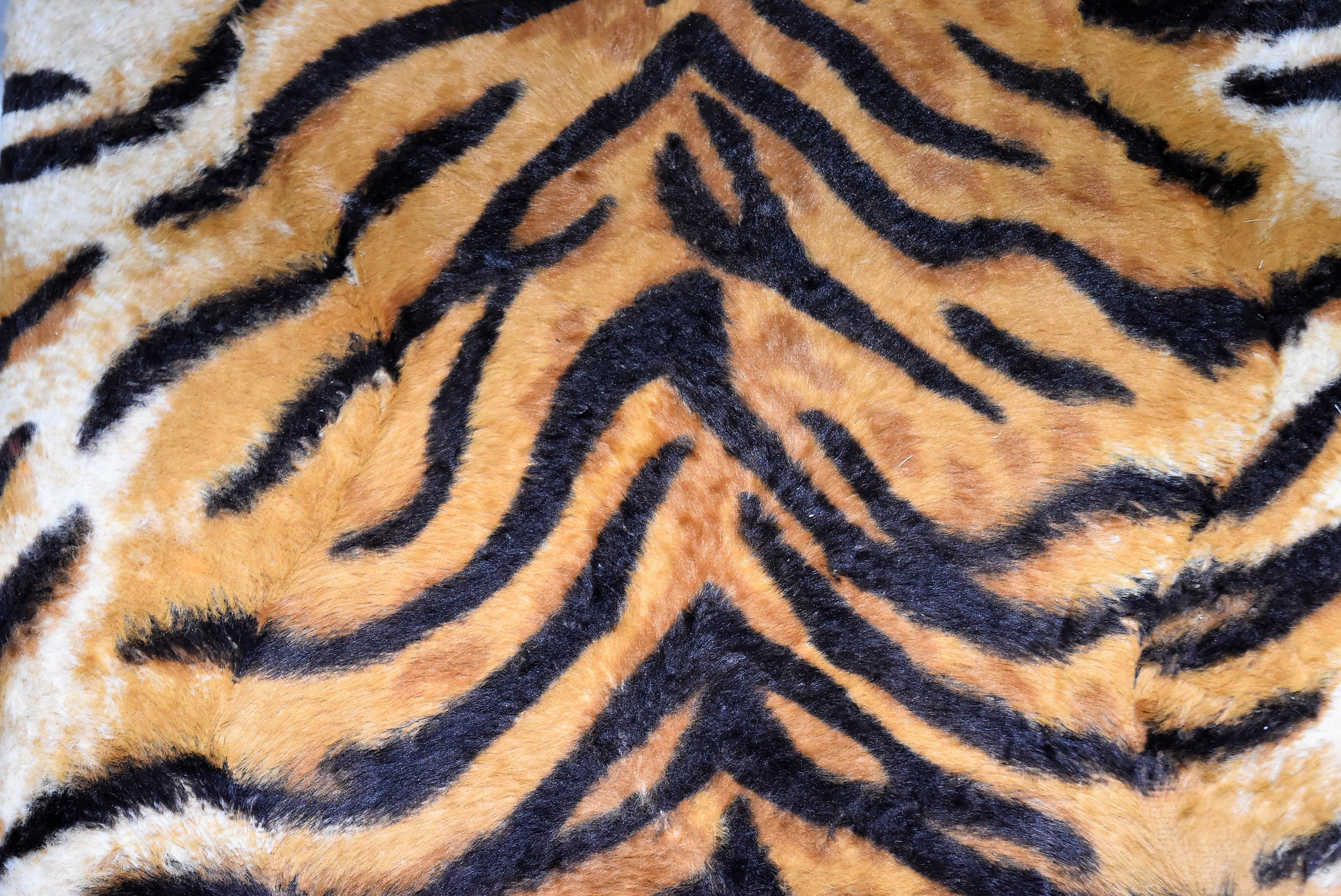 A Footstool With Faux Tiger Skin Covering. H=19, W=33, D=26cm