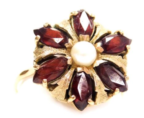 A late 20thC garnet and pearl set flower head ring, in a yellow metal basket setting, with engraved foliate decoration, size 