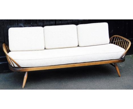 An Ercol dark elm and beech three seater sofa, with loose cushion seat and three back cushions, raised on turned legs, 208cm 