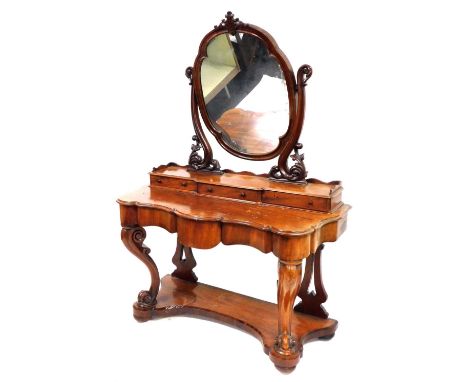 A Victorian mahogany duchess dressing table, the top with a swing frame mirror enclosed in a pierced scroll surround, the bas