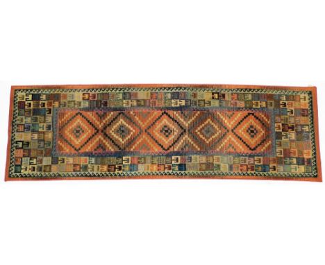 A Gabbeh red ground runner, decorated with five central lozenges, within repeating geometric borders.