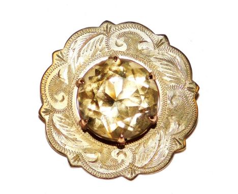 A 9ct gold and cairngorm circular brooch, claw set in a foliate engraved surround, approximately 9 carat, 5.0g.