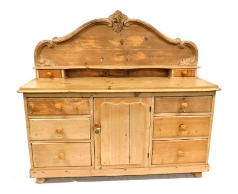 A Victorian pine sideboard, the back panel with shaped carved leaf and scroll decoration, with a shaped narrow shelf, above t