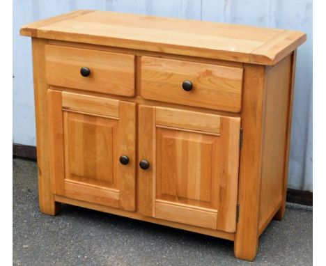 A light oak side cupboard, with a pair of drawers over a pair of cupboard doors, raised on stile supports, 82cm high, 105cm w