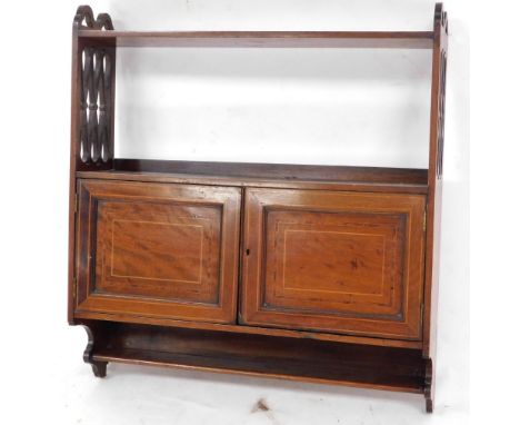 An Edwardian mahogany hanging cupboard, with satinwood cross banding and boxwood line inlay, the fretwood sides supporting a 